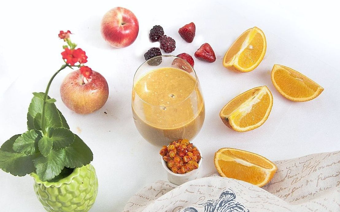 Un smoothie tropical con rodajas de piña y decoración de coco