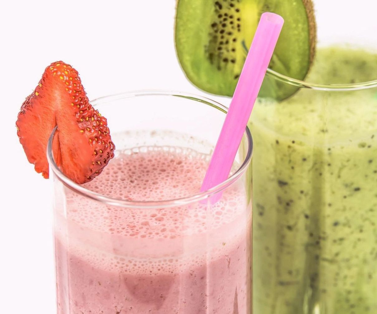 Manos vertiendo frutas en la licuadora para preparar un batido